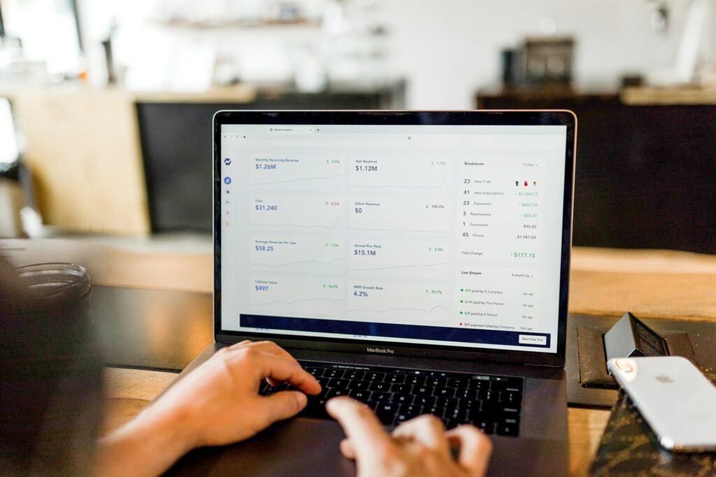 A person adding graphics and statistics to their presentation on a laptop which is on a desk for better online meetings.