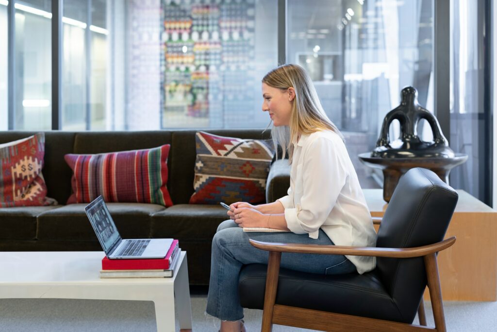 A person sat at a desk using a laptop to take part in a remote meeting.